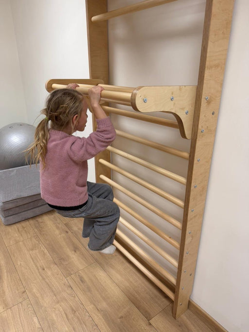 Sprossenwand Kindergarten - Kind macht Klimmzug an Kletterwand