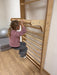 Sprossenwand Kindergarten - Kind macht Klimmzug an Kletterwand